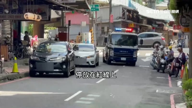 警方在街上巡邏，看到有違停車輛便進行取締。