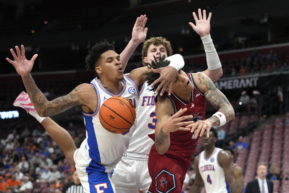 Richmond guard Dji Bailey, front right, is fouled by Florida guard Will Richard, left, during the second half of the NCAA college Orange Bowl Classic basketball game, Saturday, Dec. 9, 2023, in Sunrise, Fla. (AP Photo/Lynne Sladky)