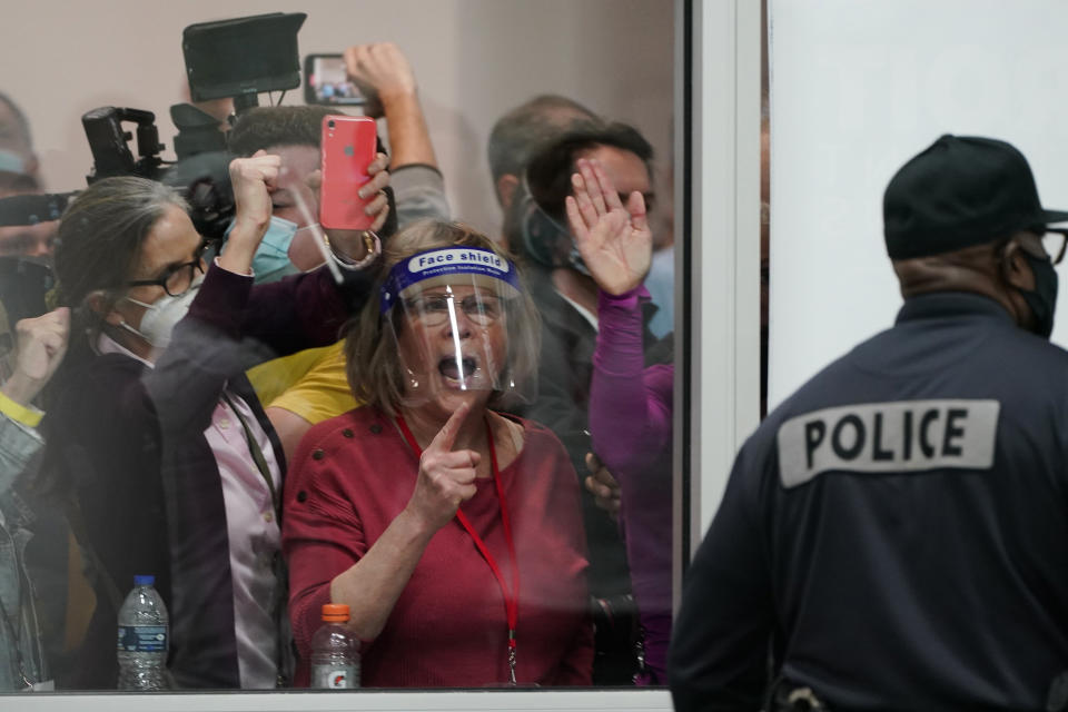 Election challengers yell as they look through the windows of the central counting board in Detroit. (Carlos Osorio / AP)