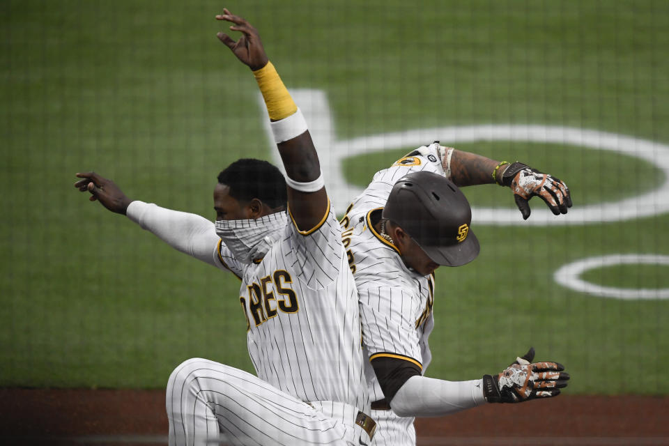 San Diego Padres' Manny Machado, right, is celebrates with teammate Jurickson Profar after hitting a two-run home run during the first inning of a baseball game against the Colorado Rockies, Monday, May 17, 2021, in San Diego. (AP Photo/Denis Poroy)