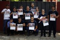 In this Jan. 12, 2019 photo, the firefighters of San Roque Gonzalez pose for a group photo before going out in the streets to sell calendars, in Asuncion, Paraguay. Since its recent publication, though, the calendar has spread like a wildfire in the socially conservative South American nation.(AP Photo/Jorge Saenz)