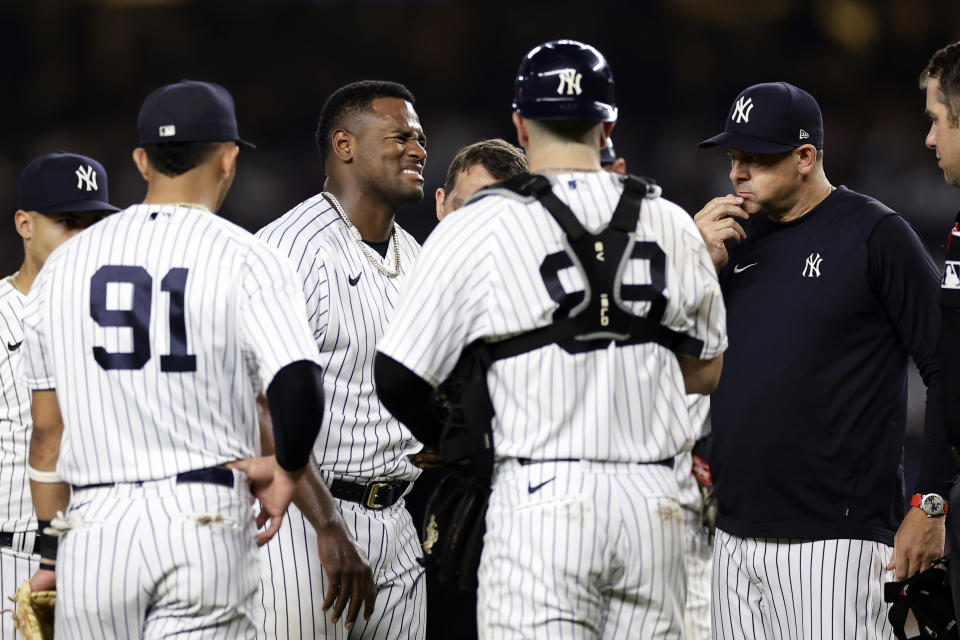 New York Yankees pitcher Luis Severino, third from left, reacts as he is checked by a trainer during the fifth inning of a baseball game against the Milwaukee Brewers, Friday, Sept. 8, 2023, in New York. (AP Photo/Adam Hunger)