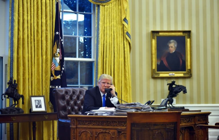 US President Donald Trump speaks on the phone with Australian Prime Minister Malcolm Turnbull in the Oval Office of the White House on January 28, 2017, in Washington, DC