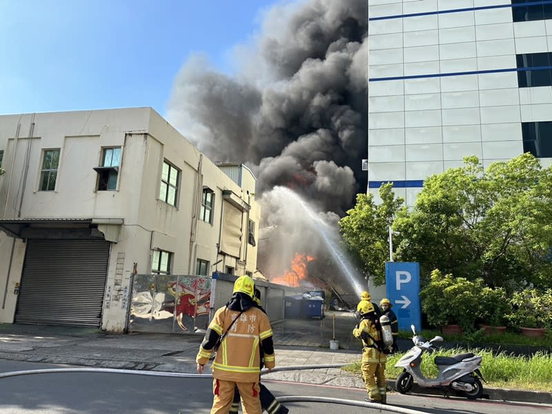 高雄市楠梓加工區中央路一處塑膠廠房14日早上7時許發生爆炸火警，現場冒出大量濃煙。高雄市消防局出動55車130人搶救，目前未接獲人員受困。（中央社／民眾提供）