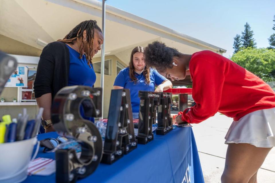 Latoya DeLong, left, a member engagement specialist for SAFE Credit Union, helps Rancho Cordova High School student Justice Johnson Patterson, right, open a savings account as student Danielle Yeater, center, participates in the school’s personal finance program on Wednesday, May 15, 2024.