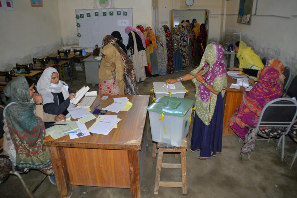 A veiled woman casts her vote as others wait their turn at a polling station during the country's parliamentary elections in Hyderabad, Pakistan, Thursday, Feb. 8, 2024. Pakistanis lined braved cold winter weather and the threat of violence to vote for a new parliament Thursday, a day after twin bombings claimed at least 30 lives in the worst election-related violence ahead of the contested elections. (AP Photo/Pervez Masih)