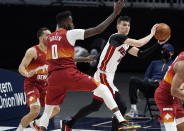 Miami Heat guard Tyler Herro, right, passes the ball as Denver Nuggets forward JaMychal Green defends during the first half of an NBA basketball game Wednesday, April 14, 2021, in Denver. (AP Photo/David Zalubowski)