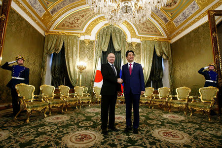 Russian President Vladimir Putin shakes hands with Japanese Prime Minister Shinzo Abe during a meeting at the Kremlin in Moscow, Russia April 27, 2017. REUTERS/Sergei Karpukhin