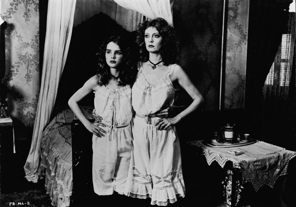 American actors Susan Sarandon (R) and Brooke Shields stand together, wearing matching slips in a still from the film, 'Pretty Baby,' directed by Louis Malle, 1975. (Photo by Paramount Pictures/Courtesy of Getty Images)