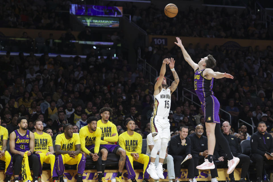 New Orleans Pelicans guard Jose Alvarado (15) shoots from 3-point range as Los Angeles Lakers guard Austin Reaves (15) defends during the first half of an NBA basketball game Friday, Feb. 9, 2024, in Los Angeles. (AP Photo/Yannick Peterhans)