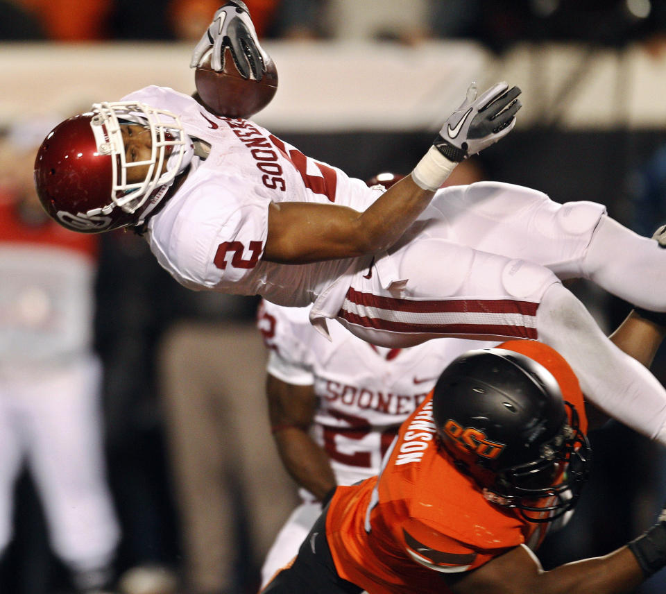 FILE - Oklahoma State linebacker Tyler Johnson, bottom, tackles Oklahoma wide receiver Trey Franks, top, in the second quarter of an NCAA college football game in Stillwater, Okla., Dec. 3, 2011. Oklahoma and Oklahoma State will meet on Saturday for the final time before Oklahoma leaves the Big 12 for the Southeastern Conference. (AP Photo/Sue Ogrocki, File)