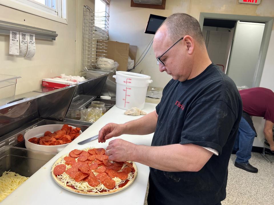 Bob Bennett, one of the new owners of Tiberio's, makes a pizza at the restaurant's new location at 416 N. Columbus St.