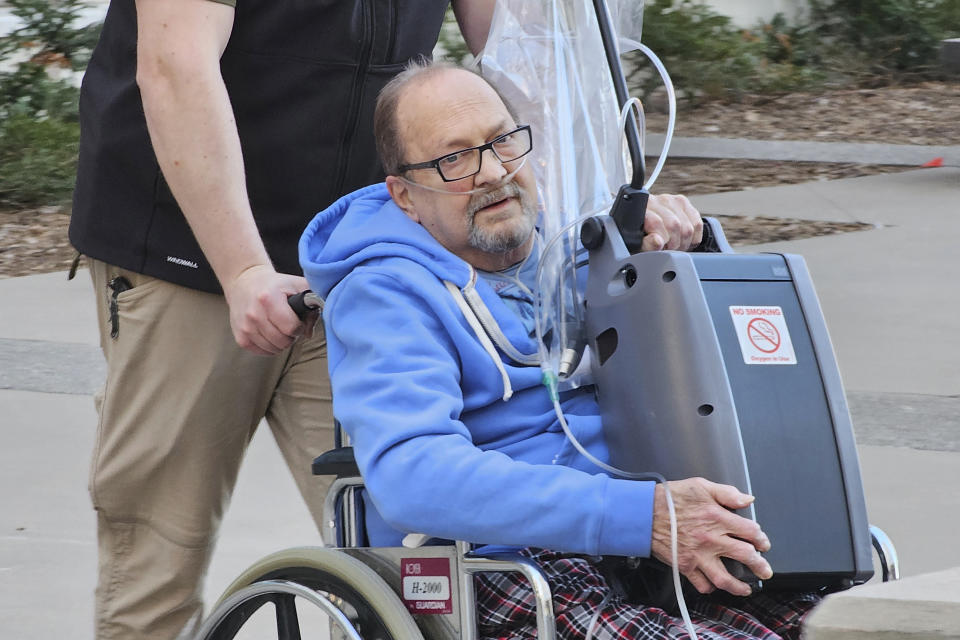 Jerry Hal Saliterman, of Crystal, Minn., is wheeled out of U.S. District Court in St. Paul, Minn., Friday, March 15, 2024, after he made his initial appearance on charges connected to the 2005 theft of a pair of ruby slippers worn by Dorothy in “The Wizard of Oz.” The FBI recovered the slippers in 2018. Another man charged in the case has already pleaded guilty and was sentenced to time served because of his ailing health. (AP Photo/Steve Karnowski)