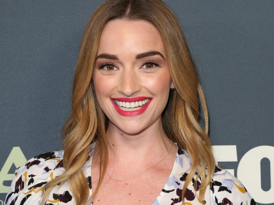 Brianne Howey wearing a patterned blouse in February 2019.