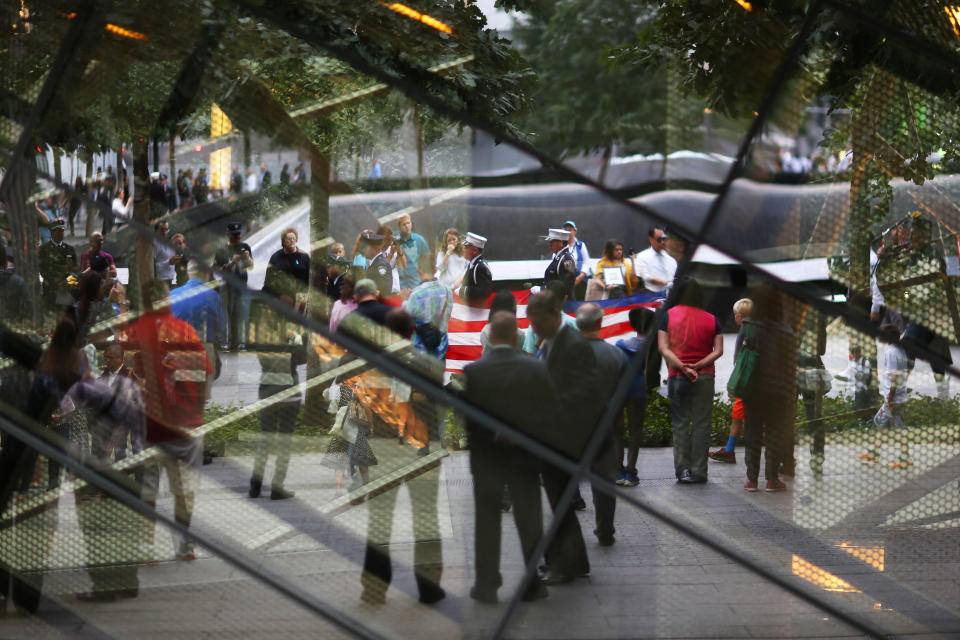 NEW YORK, NY - SEPTEMBER 11: Members of the New York Police Department, Fire Department of New York and Port Authority Police Department carry an American flag past one of the reflecting pools at the beginning of the memorial observances held at the site of the World Trade Center on September 11, 2014 in New York City. This year marks the 13th anniversary of the September 11th terrorist attacks that killed nearly 3,000 people at the World Trade Center, Pentagon and on Flight 93.  (Photo by Chang W. Lee-Pool/Getty Images)