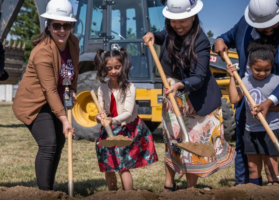 Lilia Cisneros, left, a bilingual immersion teacher at Cesar Chavez Intermediate School, joins Genesis Mendes, 7, a second-grader at Edward Kemble Elementary School, Councilwoman Mai Vang, Sacramento City Unified school board president Chinua Rhodes, and his daughter Rosa Maria, 7, a first grader at Edward Kemble, during the groundbreaking ceremony on Monday, June 5, 2023, for construction of a state-of-the-art campus to replace the aging facilities at Edward Kemble and Cesar Chavez schools.