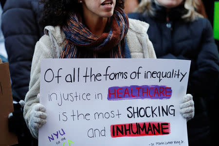 A demonstrator holds a sign while taking part in a protest against a proposed repeal of the Affordable Care Act in New York, U.S., January 30, 2017. REUTERS/Lucas Jackson