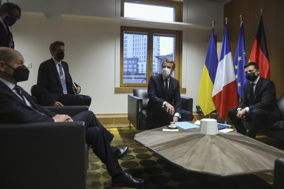 French President Emmanuel Macron, center, and German Chancellor Olaf Scholz, left, speak with Ukraine's President Volodymyr Zelenskyy, right, during a bilateral meeting on the sidelines of an Eastern Partnership Summit in Brussels, Wednesday, Dec. 15, 2021. European Union leaders meet Wednesday with partner nations on its eastern borders, with the Russian military buildup on Ukraine's border as the main point of focus. (Kenzo Tribouillard, Pool Photo via AP)