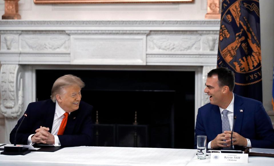 In this June 18, 2020, then-President Donald Trump laughs with Oklahoma Gov. Kevin Stitt during a roundtable at the White House with governors on the reopening of America's small businesses. (AP Photo/Alex Brandon)
