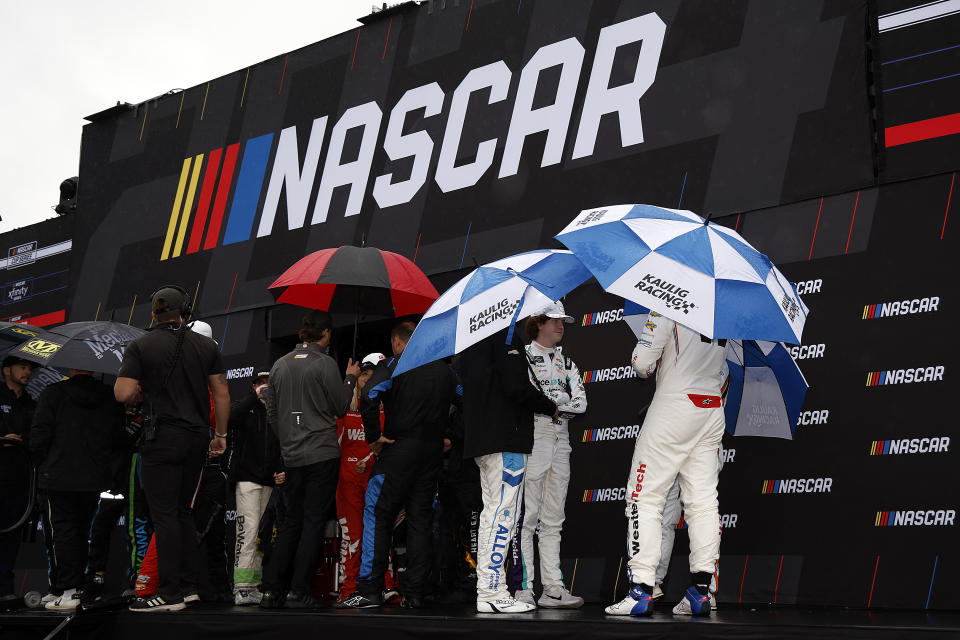 DAYTONA BEACH, FLORIDA - FEBRUARY 17: NASCAR Xfinity Series drivers under umbrellas wait backstage during pre-race ceremonies prior to the NASCAR Xfinity Series United Rentals 300 at Daytona International Speedway on February 17, 2024 in Daytona Beach, Florida. (Photo by Chris Graythen/Getty Images)