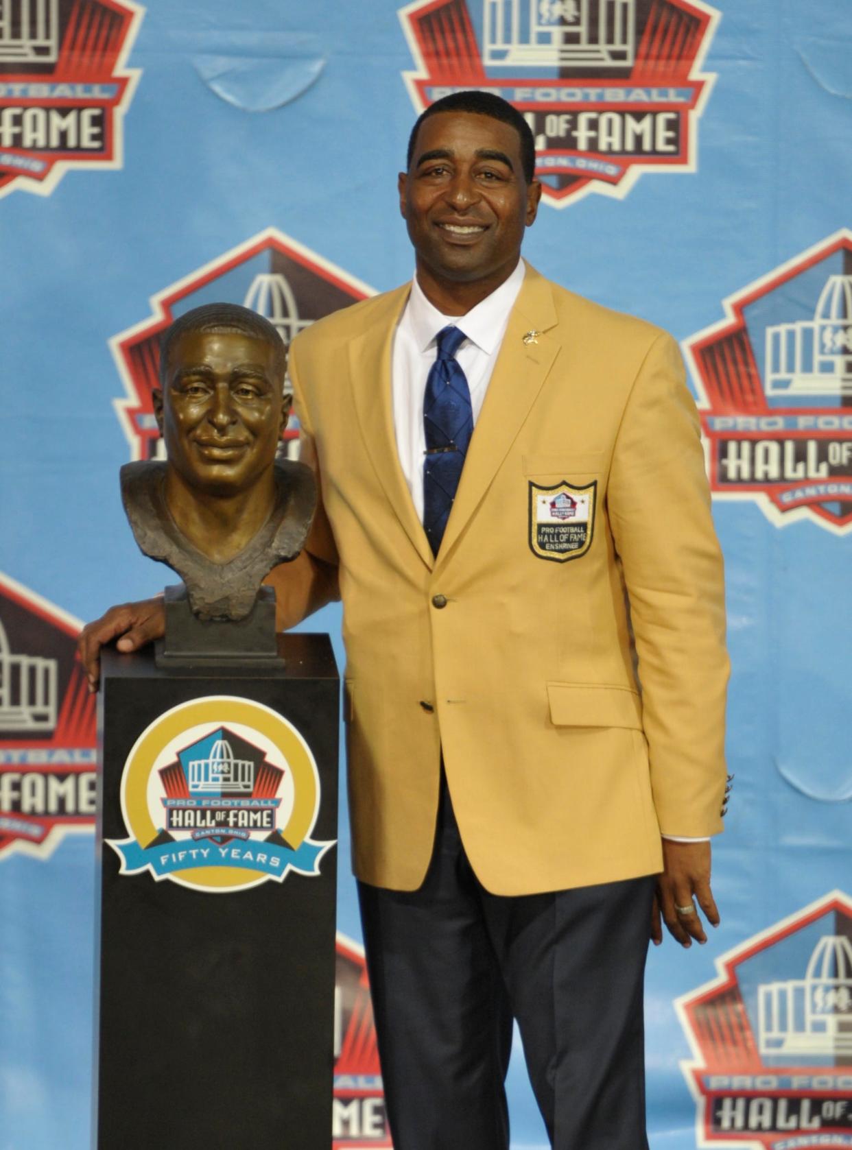 Inductee Cris Carter poses with his bust during the induction ceremony at the Pro Football Hall of Fame Saturday, Aug. 3, 2013, in Canton, Ohio. (AP Photo/David Richard)