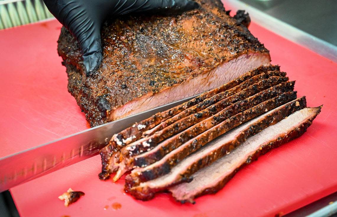 Barbecue brisket is sliced up for customers at Smoking Woods food truck in Fresno’s Brewery District in downtown Fresno on Friday, Dec. 9, 2022.