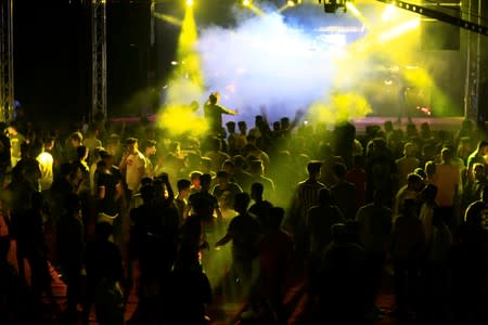 Young people dance as they attend electronic music concert with western tunes at closed Hall in Shaab Stadium for the first time in Baghdad