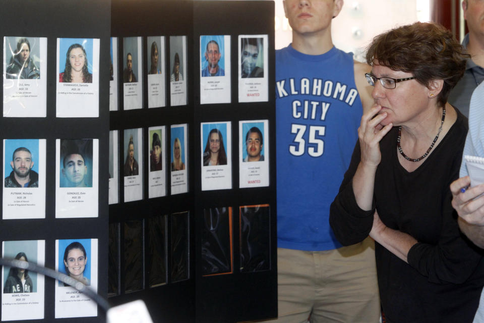 FILE - In this June 19, 2013 file photo, Springfield, Vt., resident Susan White looks over booking photos displayed at a Vermont State Police news conference to discuss the arrest of 36 people in the area as part of a large drug sweep. In his State of the State address on Jan. 8, 2014, Gov. Peter Shumlin called for treatment and education in addition to law enforcement as the best way to meet the state's growing challenge from the abuse of heroin and other opiates, which are fueling crime and wrecking lives of families in the state. (AP Photo/Toby Talbot, File)