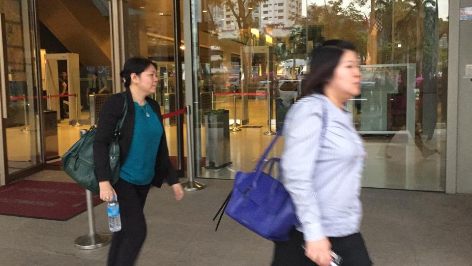 IHiS database administrator Katherine Tan (left, in green) leaves the Committee of Inquiry hearing with a friend on Friday, 21 September 2018. The COI is investigating the SingHealth cyberattacks that saw the personal particulars of 1.5 million patients compromised. PHOTO: Abdul Rahman Azhari/Yahoo News Singapore