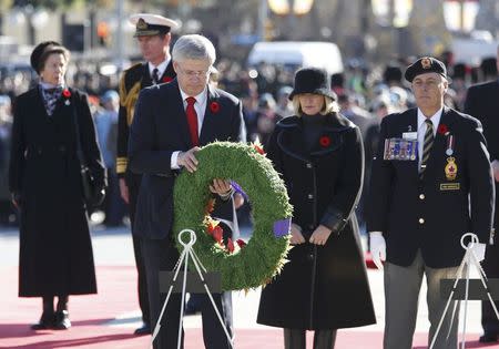 Prime Minister Stephen Harper lays a wreath as his wife Laureen and Britian's Princess Anne (L) look on, during Remembrance Day ceremonies at the National War Memorial in Ottawa November 11, 2014. REUTERS/Chris Wattie (CANADA - Tags: POLITICS MILITARY ANNIVERSARY)