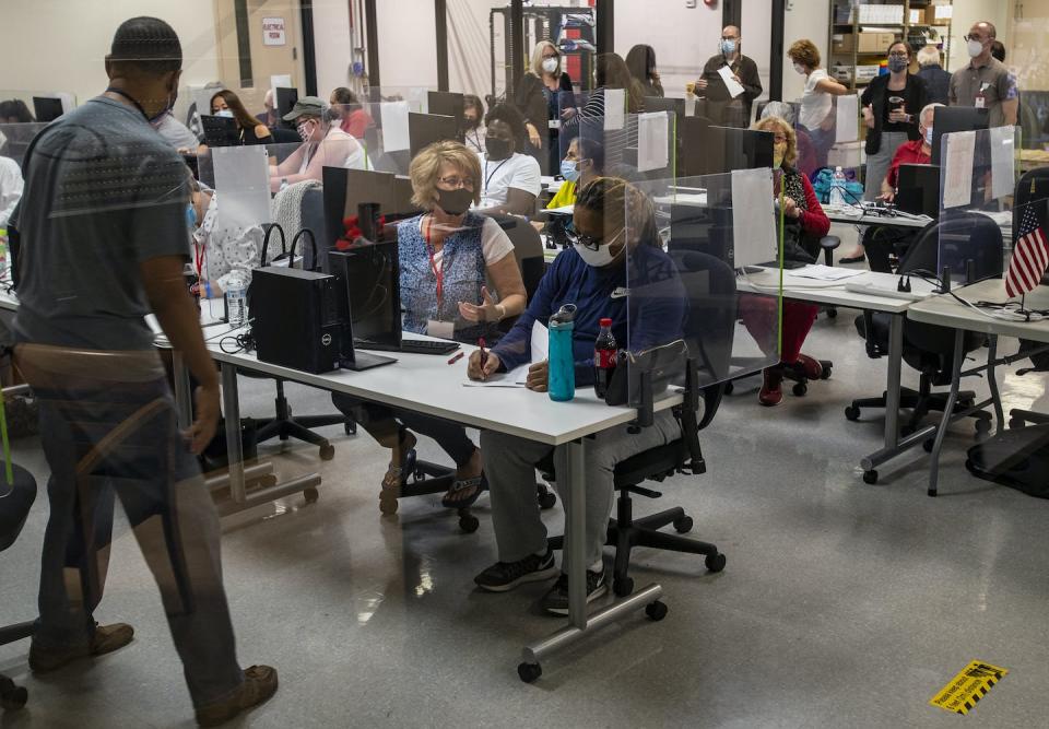 Two election workers, one a Democrat and the other a Republican, sit side by side in Arizona during the 2020 presidential election. <a href="https://www.gettyimages.com/detail/news-photo/election-workers-one-democrat-and-one-republican-sit-side-news-photo/1229498123?adppopup=true" rel="nofollow noopener" target="_blank" data-ylk="slk:Gina Ferazzi / Los Angeles Times via Getty Images;elm:context_link;itc:0;sec:content-canvas" class="link ">Gina Ferazzi / Los Angeles Times via Getty Images</a>