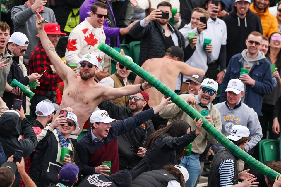 A shirtless man holds a "beer snake," or stacked plastic cups, at the Phoenix Open.