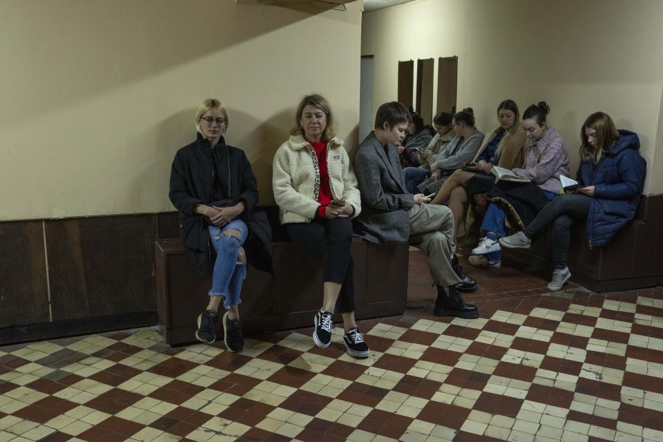 Ukrainian hat makers and employees of high-end hat designer brand Ruslan Baginskiy 'RB', take shelter as an air siren goes off, inside a college turned into a working space for the company in Lviv, western Ukraine, Friday, March 25, 2022, after fleeing Kyiv. Searching for safety but determined not to leave Ukraine, the brand is among the businesses that are uprooting amid war. (AP Photo/Nariman El-Mofty)