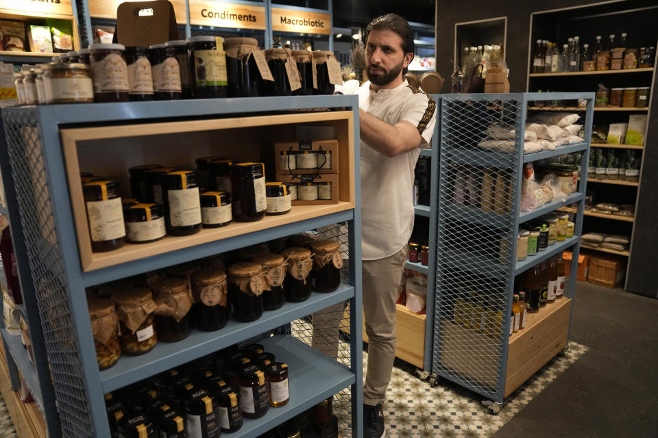 Abbas Bazzi organizes works at Le Marché Bio, the organic cafe and grocery store he co-owns, in Beirut, Lebanon, in Beirut, Lebanon Tuesday, May 30, 2023. Bazzi, who grew up in a secular family but was interested in Islam from an early age, hopes to travel to the Muslim holy city of Mecca, Saudi Arabia, for his fourth Hajj pilgrimage this month. (AP Photo/Hussein Malla)