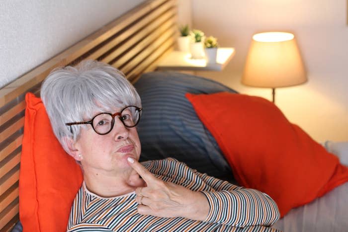 Older woman reclining and with her finger touching her chin