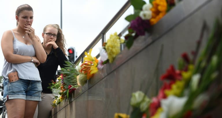 Two young women mourn at an underground station near the Olympia-Einkaufszentrum shopping mall in Munich on July 23, 2016, a day after a mass shooting there