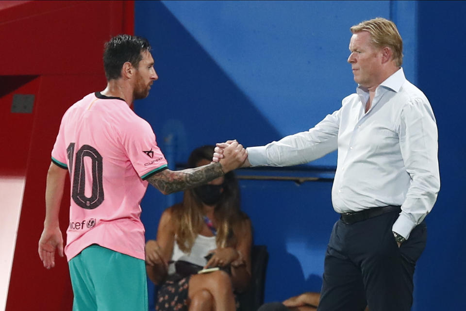 El delantero argentino del Barcelona Lionel Messi (izquierda) estrecha la mano con el técnico Ronald Koeman en un partido amistoso contra Girona, el miércoles 16 de septiembre de 2020. (AP Foto/Joan Monfort)