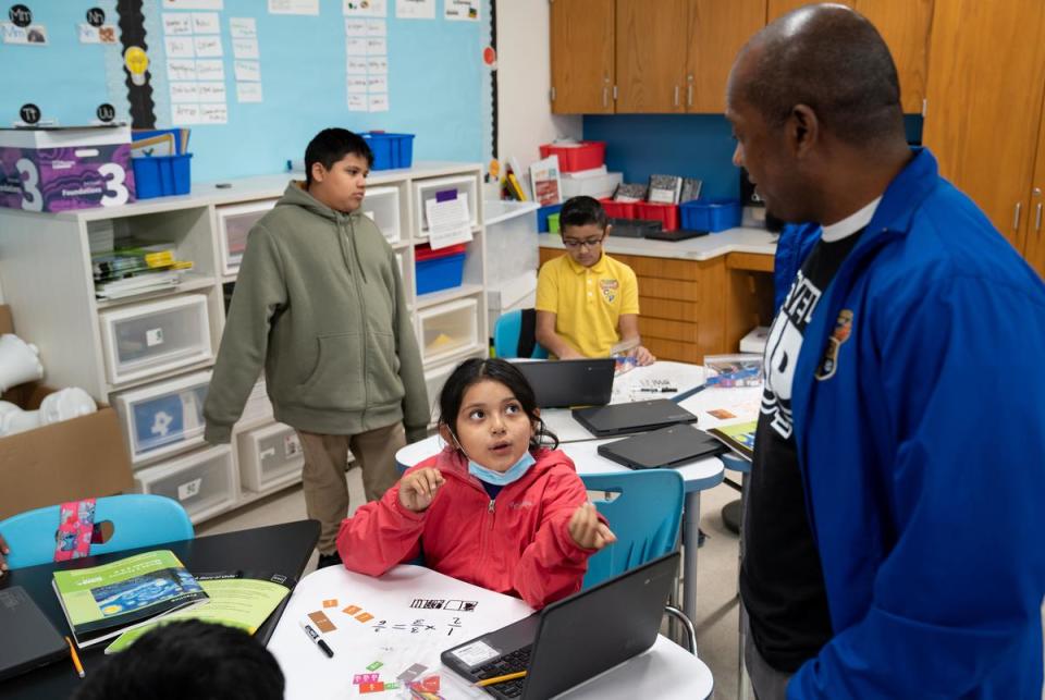 Third grade teacher Eran McGowan helps students work through math problems at the Eddie Bernice Johnson STEM Academy in Dallas, Texas on Feb. 5, 2024.