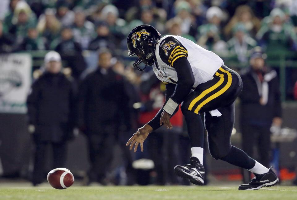 Hamilton Tiger-Cats quarterback Henry Burris reaches for the ball after missing a snap while playing against the Saskatchewan Roughriders during the first half of the CFL's 101st Grey Cup championship football game in Regina, Saskatchewan November 24, 2013. REUTERS/Mark Blinch (CANADA - Tags: SPORT FOOTBALL)