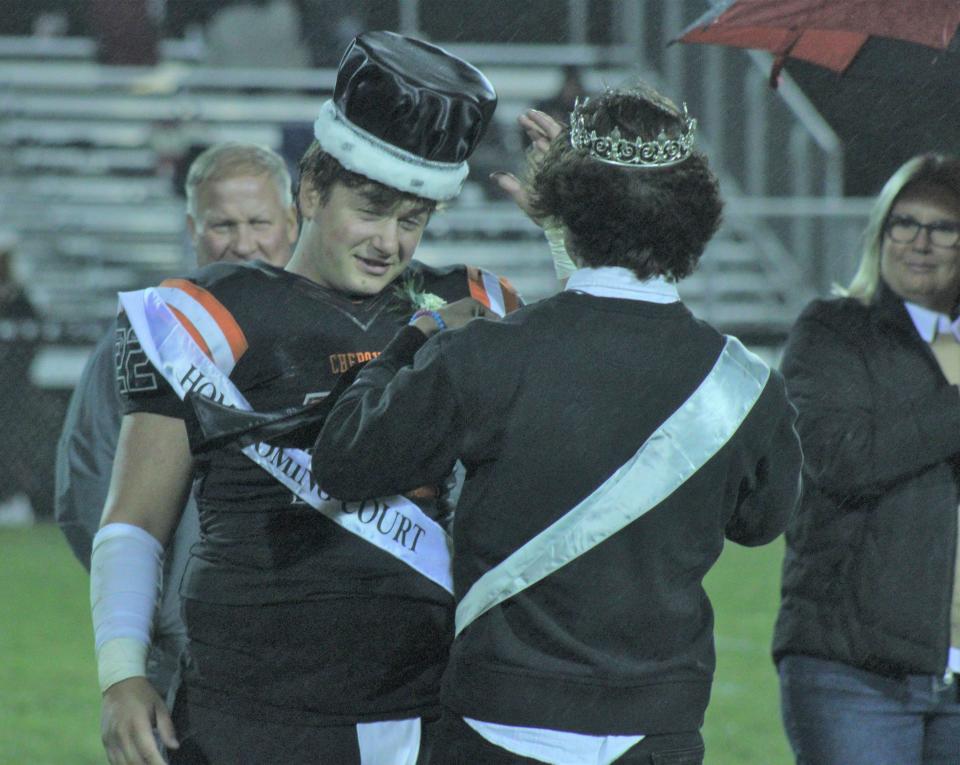 Cheboygan senior football player Dylan Balazovic (left) gets presented as 2023 homecoming king by 2022 king Keegan Mosher during halftime of Friday's clash with Boyne City at Western Avenue Field.