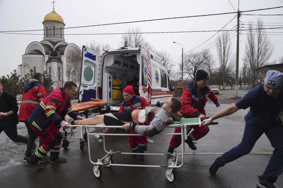 FILE - Ambulance paramedics move an injured man on a stretcher, wounded by shelling in a residential area, at the maternity hospital converted into a medical ward and used as a bomb shelter in Mariupol, Ukraine, Tuesday, March 1, 2022. Russian strikes on the key southern port city of Mariupol seriously wounded several people. (AP Photo/Evgeniy Maloletka, File)
