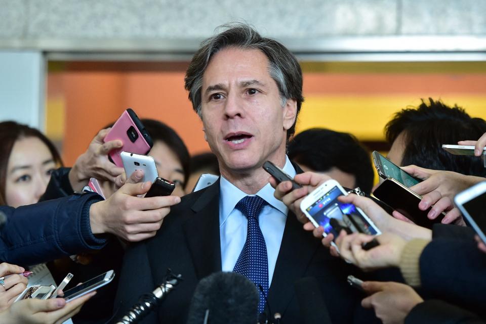 A photo of Antony Blinken speaking while surrounded by phones.