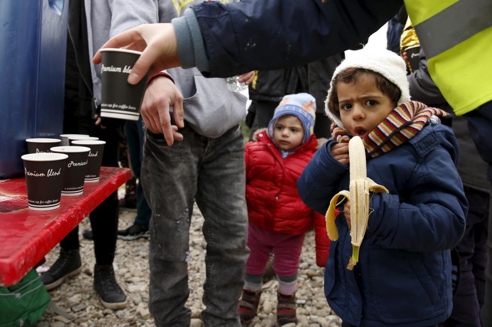 A child eats a banana as hot drinks are distributed moments after the arrival of a rubber dinghy on Lesbos, on Jan. 29, 2016.