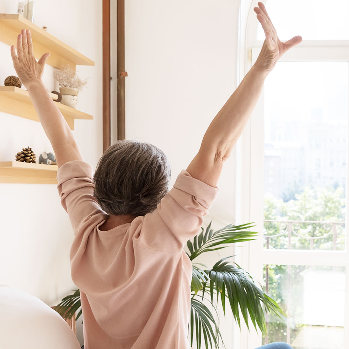 woman stretching in front of window in the morning