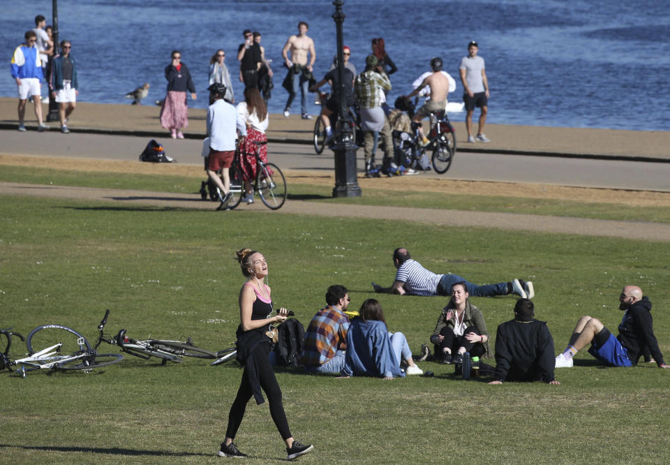 People walk, exercise and relax by the Serpentine in Hyde Park as the UK continues its lockdown to help curb the spread of coronavirus, in London, Saturday April 25, 2020. (Jonathan Brady/PA via AP)