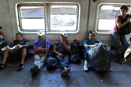 Passengers wait in the boxcar for the departure of a train in Once station, Buenos Aires, the day after a train crashed there killing 50 people and injuring at least 703