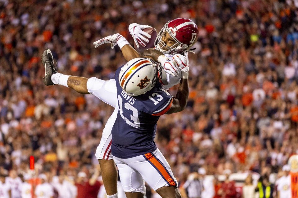 Alabama wide receiver Jaylen Waddle (17) makes a leaping touchdown pass over Auburn defensive back Javaris Davis (13) during the second half of an NCAA college football game, Saturday, Nov. 30, 2019, in Auburn, Ala. (AP Photo/Vasha Hunt)