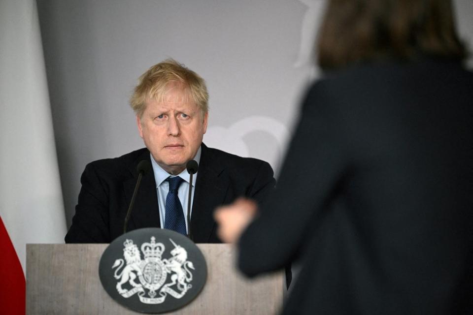 Boris Johnson fields a question from Ukrainian activist Daria Kaleniuk about the need for a no-fly zone during a news conference at the British embassy in Warsaw on Tuesday  (Reuters)