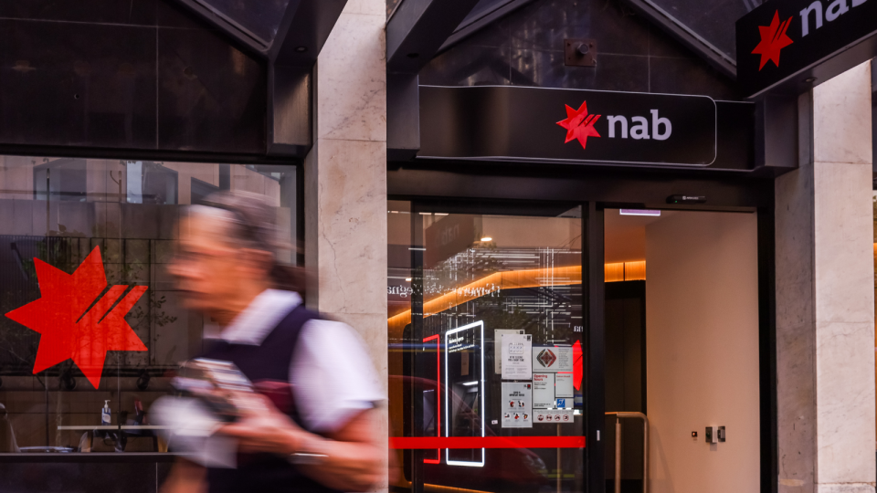 NAB branch and person walking outside.