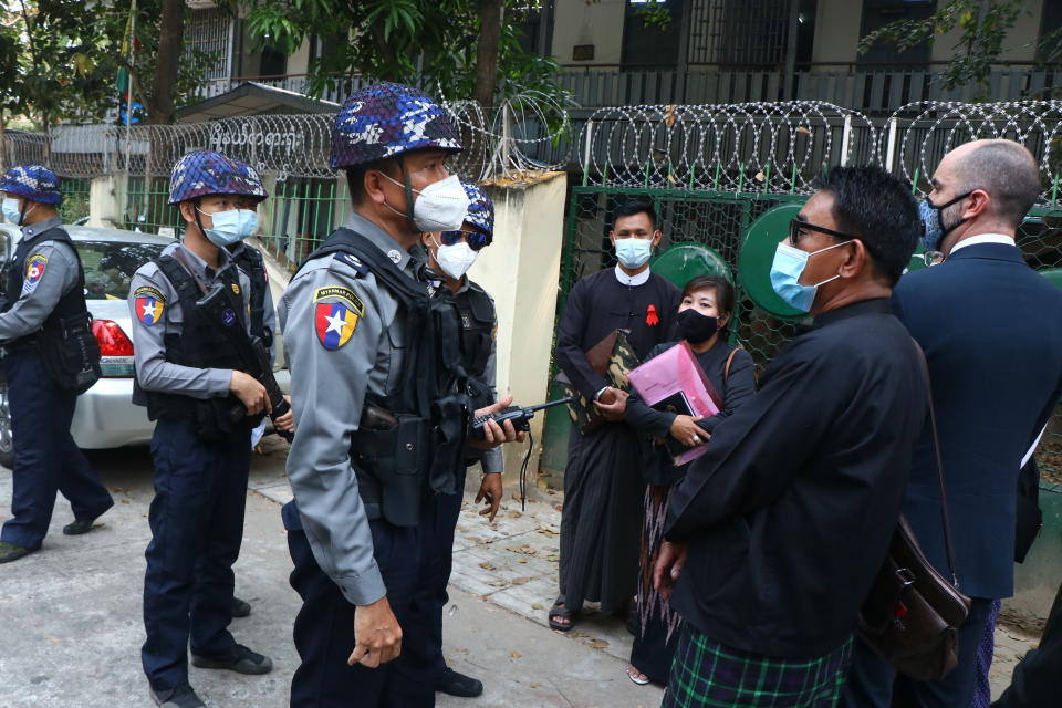 Myanmar police talk to people gathering outside the Kamayut court in Yangon, Myanmar Friday, March 12, 2021. A court in Myanmar is scheduled to hold a hearing on Friday for an Associated Press journalist detained while covering demonstrations against the military's seizure of power last month. He is facing a charge that could send him to prison for three years. (AP Photo)